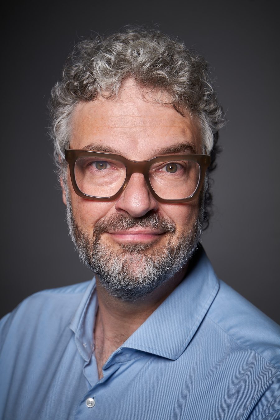 Meik Schwalm, entspannter Ausdruck, blaues Hemd