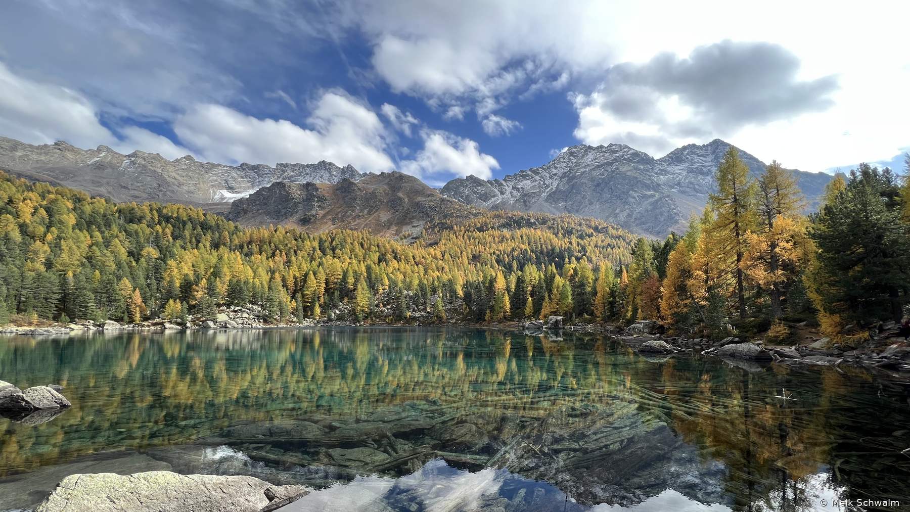 Bergsee mit Spiegelung von Wald und Gipfeln, Herbstfärbung